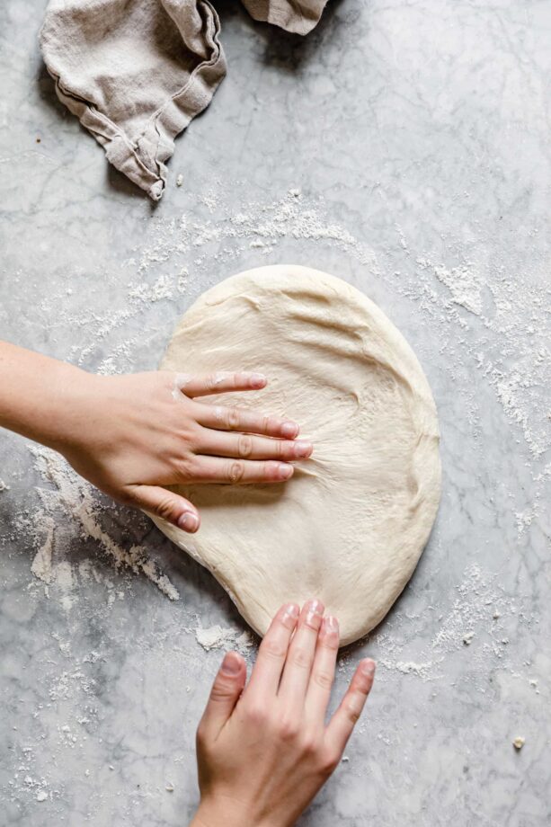 30 minute pizza dough stretched out on marble counter