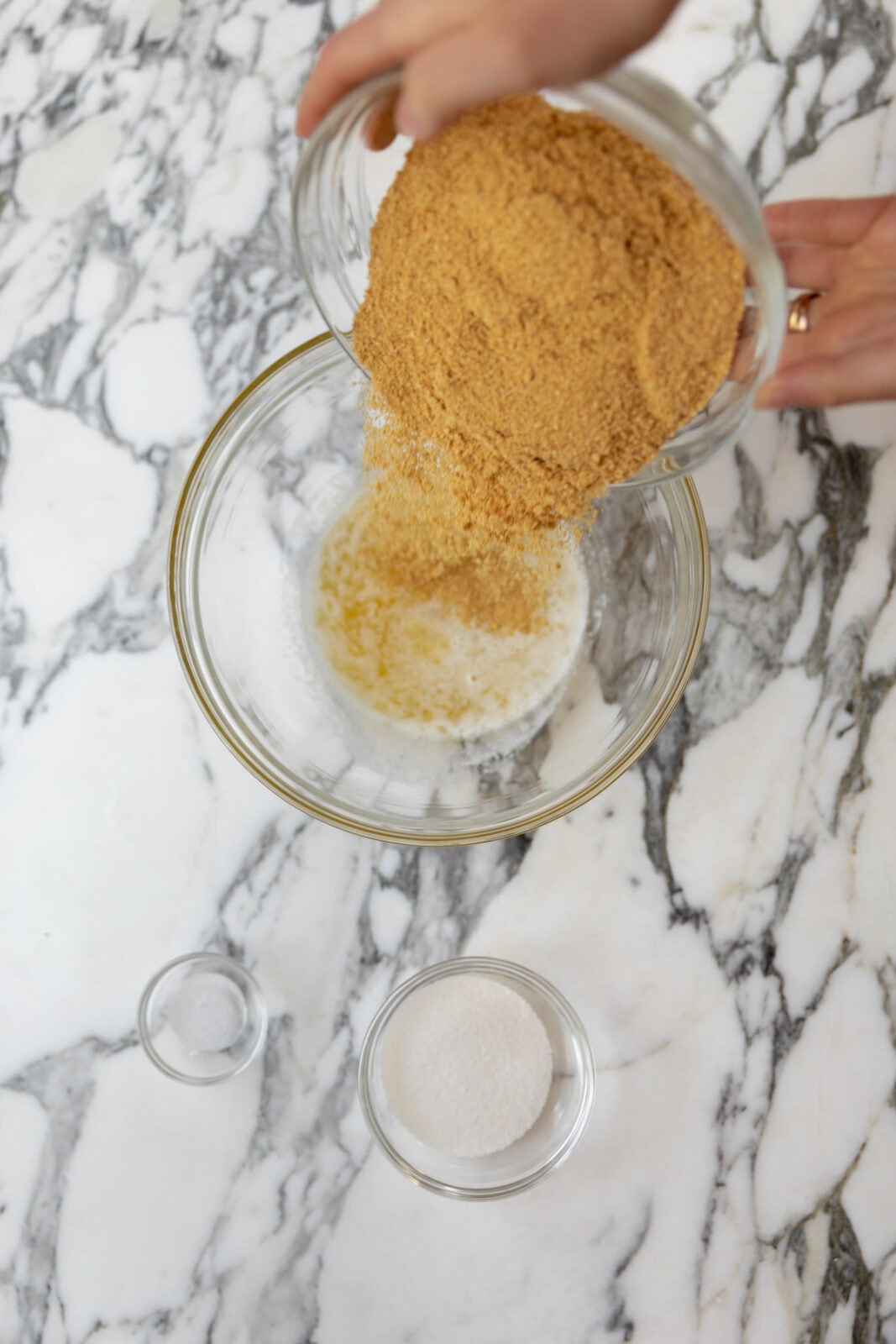 graham cracker crumbs pouring into a bowl