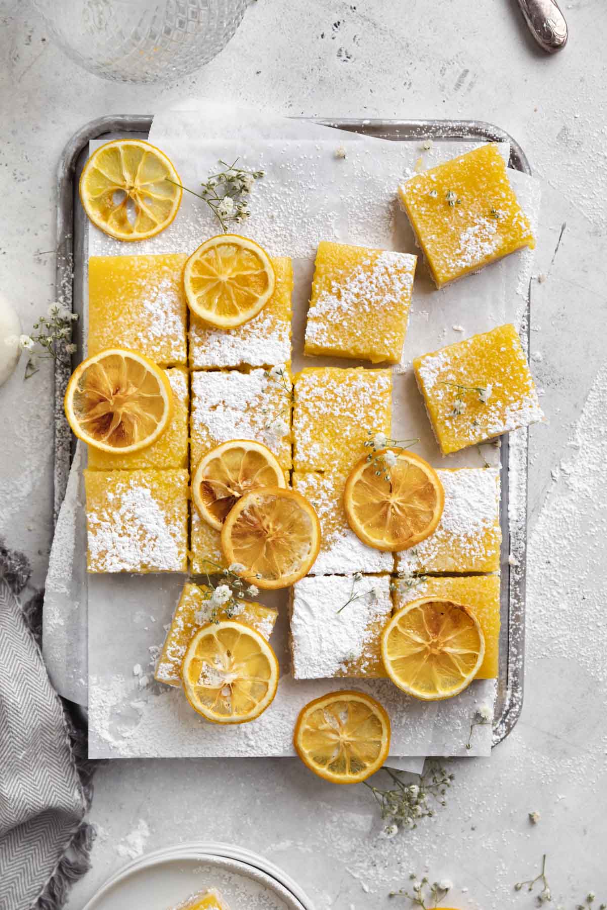 lemon bars dusted with powdered sugar on a cookie sheet