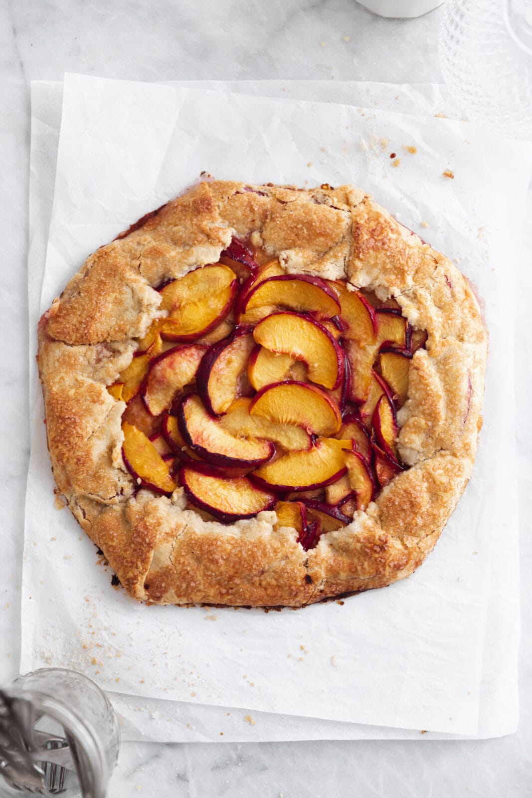 rustic peach galette on parchment paper
