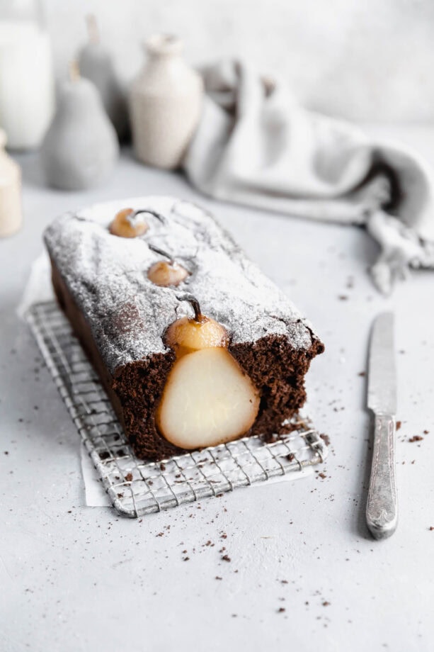 cross section of poached pear gingerbread loaf cake on a cooling rack