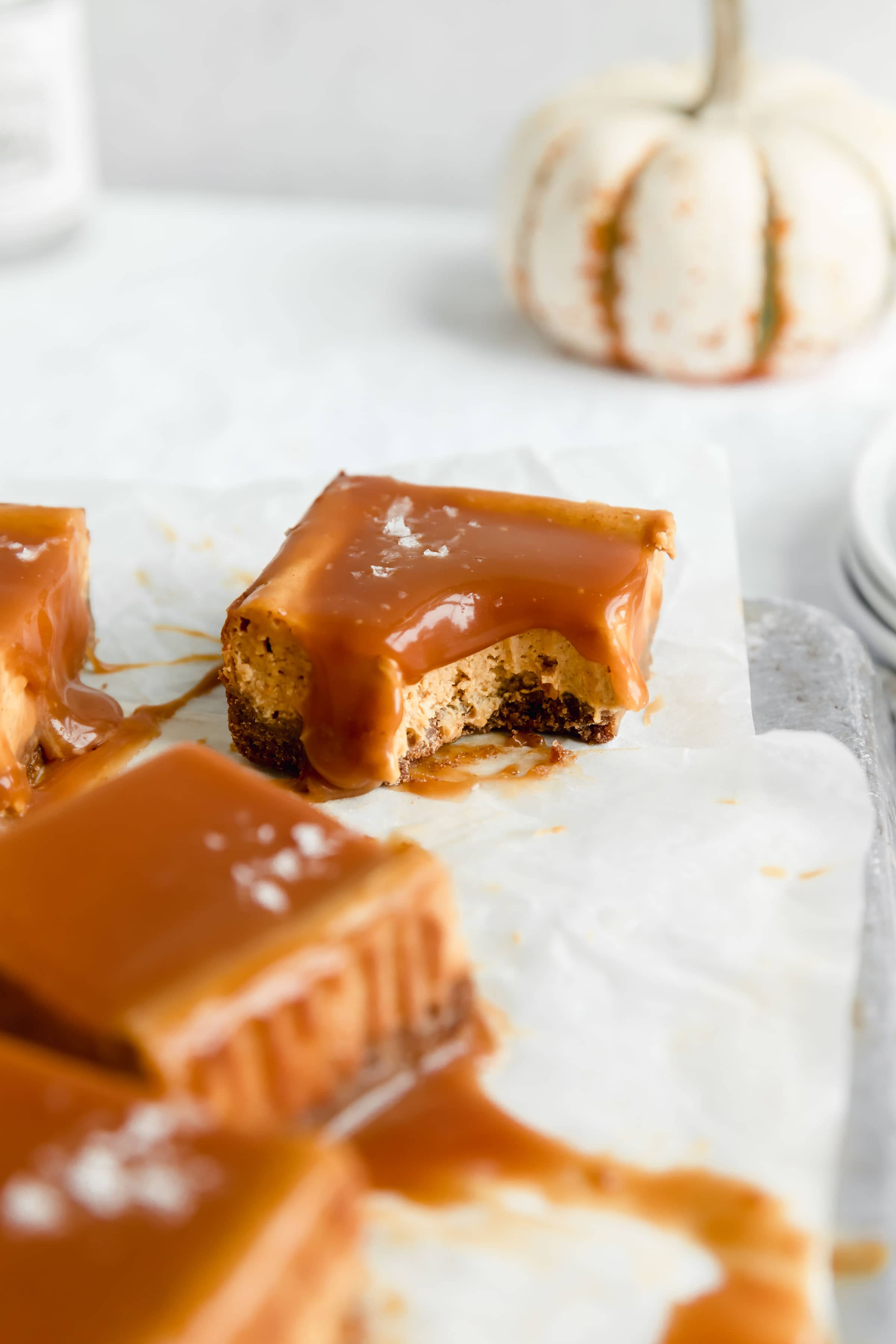 Sinfully delicious salted caramel pumpkin cheesecake bars with a bite taken out